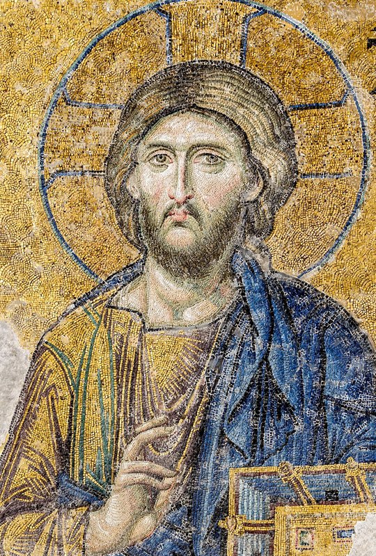 Cristo Pantocrator, de rosto sereno e auréola cruciforme sobre fundo de ouro, abençoando com a mão direita e segurando o livro, mosaico da Déesis na Santa Sofia de Istambul